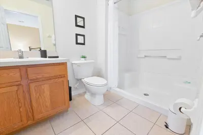 a bathroom with a toilet and a tub and a sink at 8536 Crystal Cove in Kissimmee