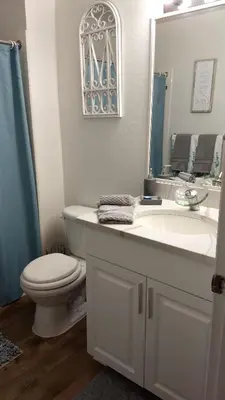 a bathroom with a sink and a toilet and a mirror at Orlando House in Kissimmee