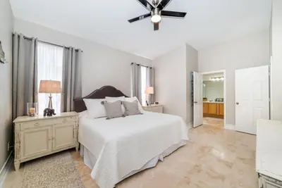 a white bedroom with a bed and a ceiling fan at Private Pool Home at Windsor Palms Resort in Kissimmee