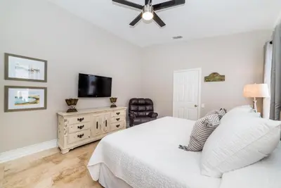 a white bedroom with a bed and a television at Private Pool Home at Windsor Palms Resort in Kissimmee