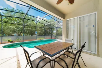 a dining room with a table and chairs next to a swimming pool at Private Pool Home at Windsor Palms Resort in Kissimmee