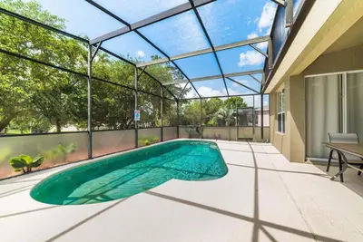 an indoor swimming pool in a house with a glass ceiling at Private Pool Home at Windsor Palms Resort in Kissimmee