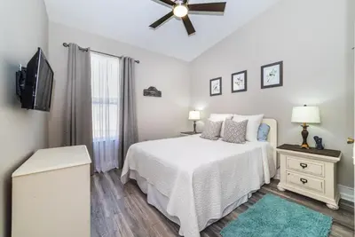 a white bedroom with a bed and a ceiling fan at Private Pool Home at Windsor Palms Resort in Kissimmee