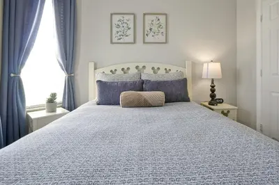 a bedroom with a large bed with blue pillows at Sunny Condo Retreat at Windsor Hills in Orlando