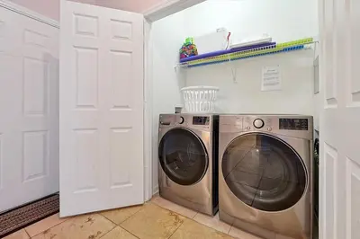 a washing machine in a laundry room with a door at Best Family Friendly Spot at Windsor Hills in Orlando