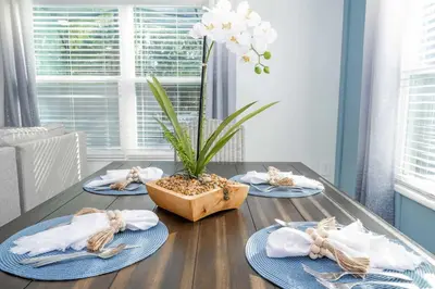 a table with four plates and a plant on it at NEW to Market 5 Bed - Storey Lake Retreat in Kissimmee