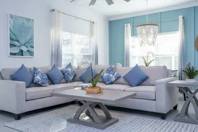 a living room with a couch with blue pillows at NEW to Market 5 Bed - Storey Lake Retreat in Kissimmee
