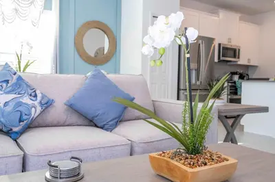 a living room with a couch and a vase of flowers on a table at NEW to Market 5 Bed - Storey Lake Retreat in Kissimmee