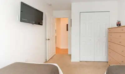 a bedroom with a white door and a tv on a wall at Townhome at Emerald Island Resort in Kissimmee