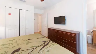 a bedroom with a dresser and a flat screen tv at Townhome at Emerald Island Resort in Kissimmee