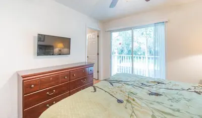 a bedroom with a bed and a dresser and a window at Townhome at Emerald Island Resort in Kissimmee
