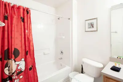 a bathroom with a red shower curtain and a toilet at Private Pool Townhome at Encantada Resort in Kissimmee