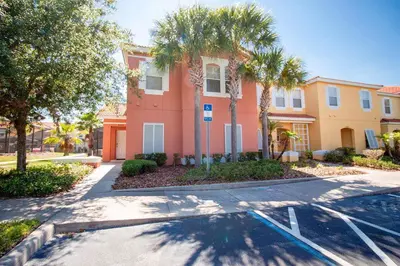 a house with palm trees in front of a street at Private Pool Townhome at Encantada Resort in Kissimmee