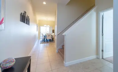 a hallway of a home with a staircase and a dining room at Private Pool Townhome at Paradise Palms Resort in Kissimmee