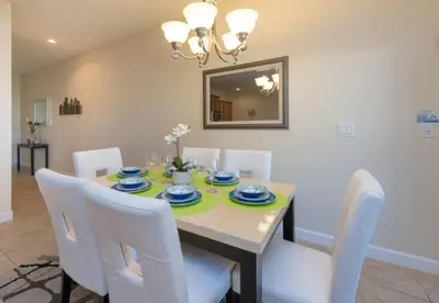 a dining room with a table and white chairs at Private Pool Townhome at Paradise Palms Resort in Kissimmee
