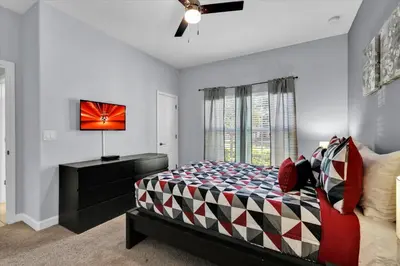 a bedroom with a bed and a dresser and a window at 3069 Beach Palm in Kissimmee