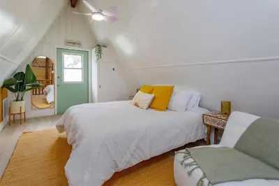 a attic bedroom with two beds and a chair at Hope Home in Clermont