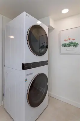 a washer and dryer with a tv on a wall at Hope Home in Clermont