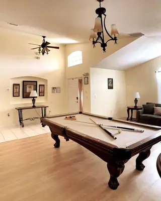 a large living room with a pool table at Minutes to Disney! Spacious Home w/ Private Pool, Themed Rooms! in Orlando