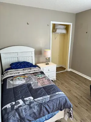a bedroom with a bed and a night stand with a lamp at Grand Holiday 3BR Condo Resort near Disney Parks in Kissimmee