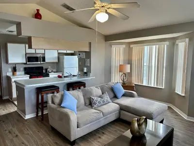 a living room with a couch and a kitchen at Grand Holiday 3BR Condo Resort near Disney Parks in Kissimmee