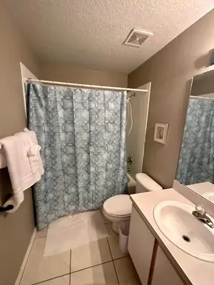 a bathroom with a toilet and a shower curtain at Grand Holiday 3BR Condo Resort near Disney Parks in Kissimmee