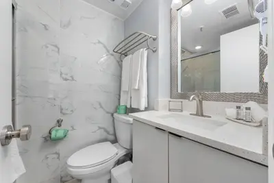a white bathroom with a toilet and a sink at Exclusive Second-Floor Apartment in Orlando