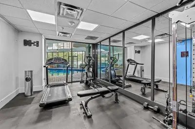 a gym with several tread machines and mirrors at Exclusive Second-Floor Apartment in Orlando
