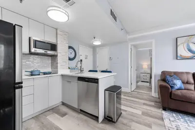 a kitchen with white cabinets and a couch in a room at Exclusive Second-Floor Apartment in Orlando