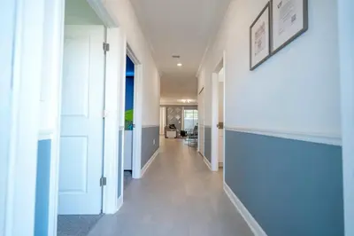 a hallway with white walls and white doors and a hallway with a hallway at Wonderful 5 Bd w Pool @ Storey Lake Resort 2545 in Kissimmee