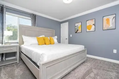 a bedroom with a large bed with yellow pillows at Wonderful 5 Bd w Pool @ Storey Lake Resort 2545 in Kissimmee