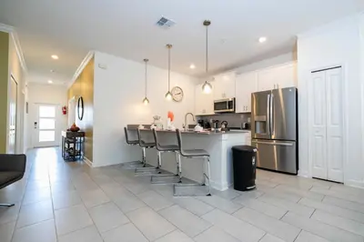a kitchen with a row of bar stools at Free Waterpark 5Bd Close to Disney Private Pool 2497 in Kissimmee