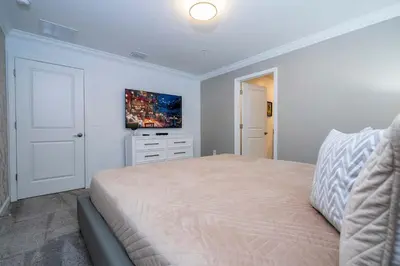 a bedroom with a bed and a tv on the wall at Free Waterpark 5Bd Close to Disney Private Pool 2497 in Kissimmee