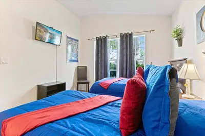 a bedroom with two beds with blue and red sheets at 4676 Cumbrian Lakes in Kissimmee