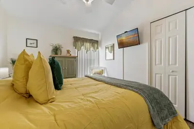 a bedroom with a large bed with yellow pillows at 4676 Cumbrian Lakes in Kissimmee
