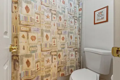 a bathroom with a toilet and a shower curtain at 4676 Cumbrian Lakes in Kissimmee