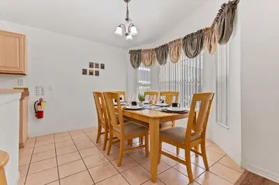 a dining room with a wooden table and chairs at 4676 Cumbrian Lakes in Kissimmee