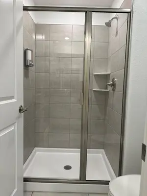 a shower with a glass door in a bathroom at COLORING in Kissimmee