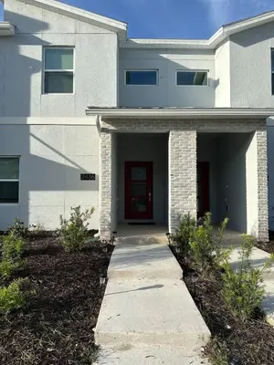 a white house with a red door and a sidewalk at COLORING in Kissimmee