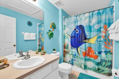 a blue bathroom with a toilet and a shower curtain at 7644 Sir Kaufmann in Kissimmee