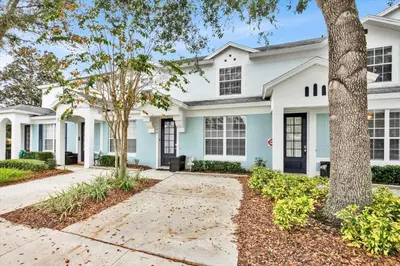 a white house with black windows and trees at 7644 Sir Kaufmann in Kissimmee