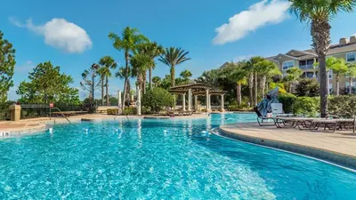 a pool at a resort with palm trees and a gazebo at 7644 Sir Kaufmann in Kissimmee