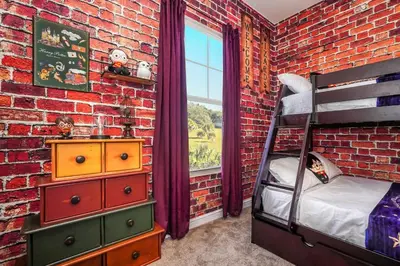 a bedroom with a brick wall and a bunk bed at Magical Themed Home Near Disney in Orlando