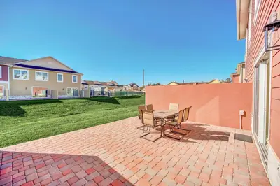 a patio with a table and chairs on a brick yard at Magical Themed Home Near Disney in Orlando