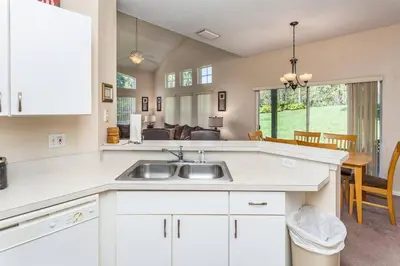 a kitchen with a sink and a living room at 2764 Sun Key in Kissimmee