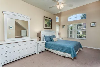 a bedroom with a bed and a dresser and a mirror at 2764 Sun Key in Kissimmee