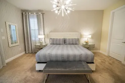a bedroom with a bed and a chandelier at Stunning Luxury 9BR Encore Villa by Disney in Orlando