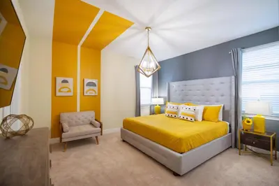 a bedroom with a yellow bed and a chair at Stunning Luxury 9BR Encore Villa by Disney in Orlando