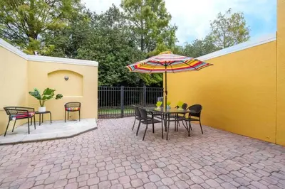 a patio with a table with an umbrella and chairs at Marvelous 3Bd w Jacuzzi at Terra Verde Resort 4757 in Kissimmee