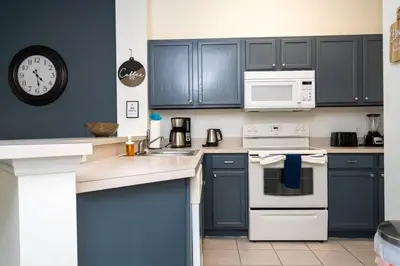 a kitchen with blue cabinets and white appliances at Marvelous 3Bd w Jacuzzi at Terra Verde Resort 4757 in Kissimmee